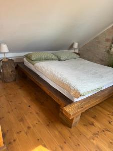 uma cama com uma estrutura de madeira num quarto em Pelini - 1 em Szentendre