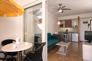 salon i kuchnia ze stołem i krzesłami w obiekcie Apartamentos Montemayor w mieście Playa del Ingles