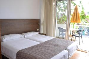 a bedroom with a bed and a sliding glass door at Apartamentos Montemayor in Playa del Ingles