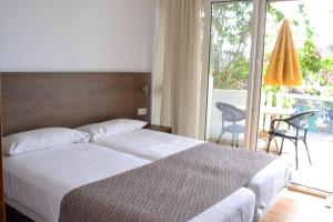 sypialnia z łóżkiem i przesuwanymi szklanymi drzwiami w obiekcie Apartamentos Montemayor w mieście Playa del Ingles