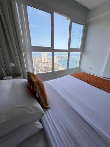 Sea View Paradise في الإسكندرية: غرفة نوم بسرير مع نافذة كبيرة
