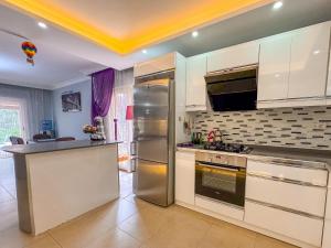 a kitchen with white cabinets and a stainless steel refrigerator at Villa Siesta Kusadasi in Kusadası