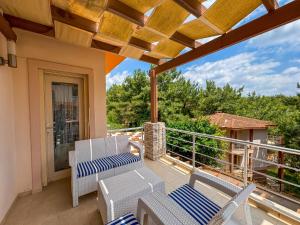 a patio with chairs and tables on a balcony at Villa Siesta Kusadasi in Kuşadası