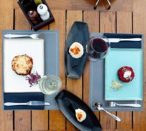 a table with plates of food and a glass of wine at Priuli Heritage Suites in Split