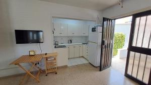 a kitchen with a desk and a refrigerator and a table at Seaside 2BR Apartment 30m from Sea & Free Parking in Oroklini