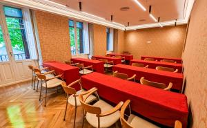 una sala de conferencias con mesas y sillas rojas en Hotel Opera, en Madrid