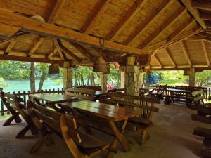a group of wooden tables and chairs in a pavilion at Camping Drina in Foča +24 photos