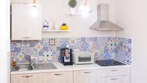 cocina con azulejos azules y blancos en la pared en Cala Di Luna House, en Vietri