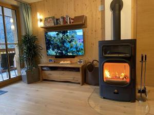 uma sala de estar com lareira e televisão em Residenz-Traithenblick em Bayrischzell