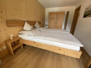 um quarto com uma cama grande e uma cabeceira em madeira em Residenz-Traithenblick em Bayrischzell