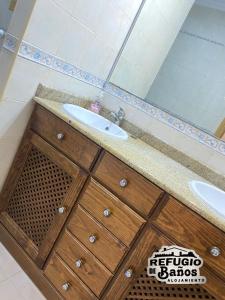 ein Bad mit einem Waschbecken und einem Spiegel in der Unterkunft Refugio de Baños in Baños de la Encina