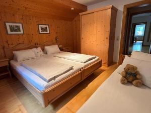 um quarto com uma cama e um urso de peluche no chão em Jörgleggerhof em Nikolsdorf