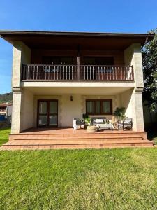 ein großes Haus mit einem Balkon auf einer gemauerten Terrasse in der Unterkunft Casa en Treceño in Treceño