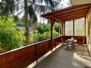 a wooden porch with a table and chairs on it at LaBONI Apartman in Miskolctapolca