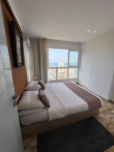 - une chambre avec un grand lit et une grande fenêtre dans l'établissement SEA VIEW PARADISE 2, à Alexandrie