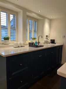 a kitchen with a black and white counter and windows at The Barn, Roughlee in Barrowford