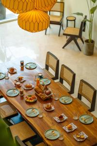 a wooden table with plates of food on it at Minimalist Panjim in Marmagao