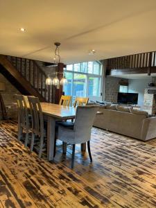 a dining room and living room with a table and chairs at The Barn, Roughlee in Barrowford