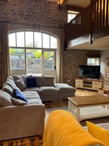 a living room with a couch and a tv at The Barn, Roughlee in Barrowford