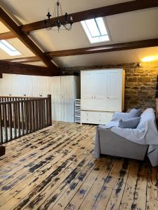 a bedroom with a bed and a wooden floor at The Barn, Roughlee in Barrowford