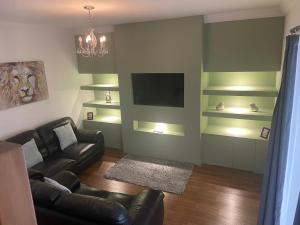 a living room with a couch and a television at Sunderland Self Catering 2 - Violet Cottage Free Parking in Sunderland