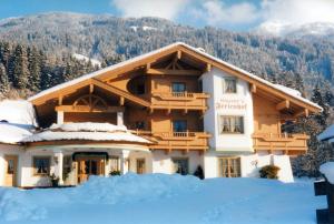 un edificio con la neve davanti di Hauser's Ferienhof a Hart im Zillertal