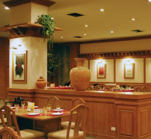 a restaurant with a table and a vase on the counter at Rimpao Hotel in Kalasin