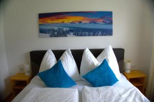 ウダーンスにあるFerienwohnung Gartnerのベッドルーム1室(青と白の枕が備わるベッド1台付)
