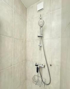 a shower with a shower head in a bathroom at Charmant T1 entre ville et lac avec balcon in Aix-les-Bains