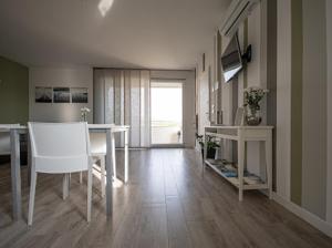ein Wohnzimmer mit einem Tisch und ein weißes Esszimmer in der Unterkunft Flyingaway in Borso del Grappa