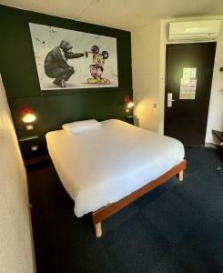 um quarto com uma cama com uma fotografia de um macaco em The Originals Access, Hôtel Limoges Nord em Limoges