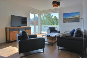 a living room with two couches and a television at Villa Baltic Star in Börgerende-Rethwisch