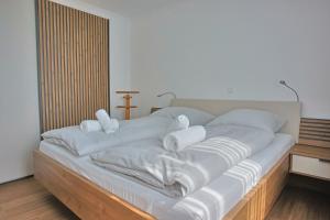 a bed with white sheets and pillows on it at Villa Baltic Star in Börgerende-Rethwisch