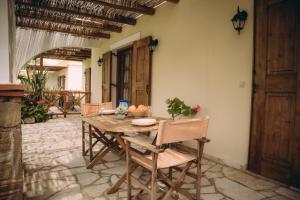 a wooden table and chairs in a room at Trikalioti's Lush Estate Apartments in Palouki