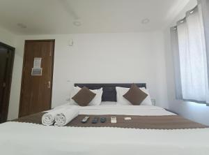 een slaapkamer met een groot wit bed met kussens bij Premium Hotel Deoli Khanpur in New Delhi