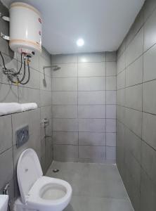 een witte badkamer met een toilet en een douche bij Premium Hotel Deoli Khanpur in New Delhi