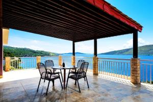 einen Tisch und Stühle auf einem Balkon mit Blick auf das Wasser in der Unterkunft Seaside Villa Lara - Pinienwald, beheizter Swimming pool in Poljica