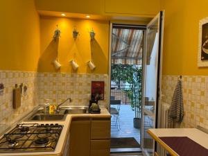 uma cozinha amarela com um lavatório e um fogão em Rosanna House - Vedano Al Lambro em Monza