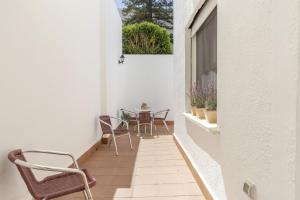 a small balcony with chairs and a table on it at Apartamento independiente en Playa de Regla. in Chipiona