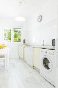 a white kitchen with a washer and dryer at Apartamento independiente en Playa de Regla. in Chipiona +3 photos