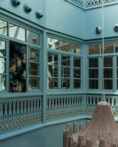 a blue building with windows and a chandelier at Puris Moedani Boutique Hotel in Tbilisi City