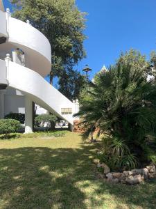 eine Palme vor einem weißen Gebäude in der Unterkunft La Barrosa in Novo Sancti Petri