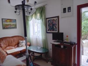 een woonkamer met een stoel en een bureau met een computer bij Apartment Botanicheskiy Sad in Sutomore