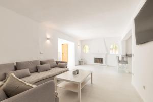 Sala de estar blanca con sofá y mesa en Villa Andes, en Casas de Torrat