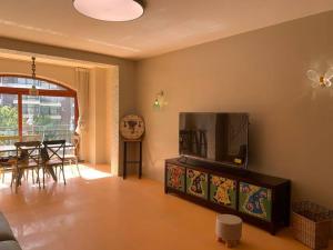un salon avec une télévision et une salle à manger dans l'établissement Alps Rongchen Resort Apartment, à Chongli