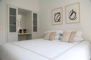 a white bedroom with a large white bed at Close to Everything Bright Modern Apartment in Nazaré