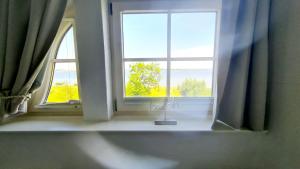 una ventana en una habitación con vistas al océano en Insel Landhaus Feuerstein, en Gager