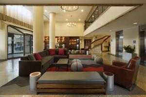 Four Points by Sheraton Hotel & Conference Centre Gatineau-Ottawa في غاتينو: غرفة معيشة مع كنب وسجادة