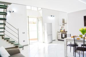 a white kitchen with a staircase and a table at B&B Peonies in Castellammare di Stabia