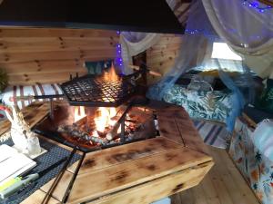 a fire pit in a room with a bed at Private Lakeside Retreat in Renac